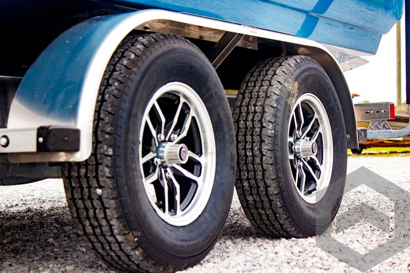 Slide: The Image of Trailer wheels of 2025 Tidewater 2410 Bay Max boat on gravel surface. - 10