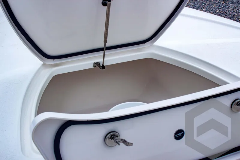 Slide: The Image of 2025 Tidewater 2410 Bay Max storage compartment with open lid and secure lock mechanism. - 22