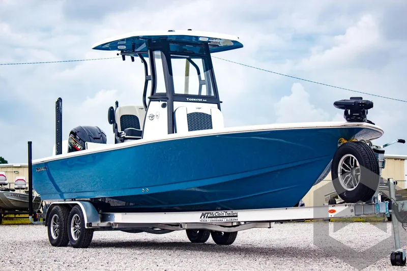 Slide: The Image of 2025 Tidewater 2410 Bay Max boat on trailer, blue hull, parked outdoors. - 4