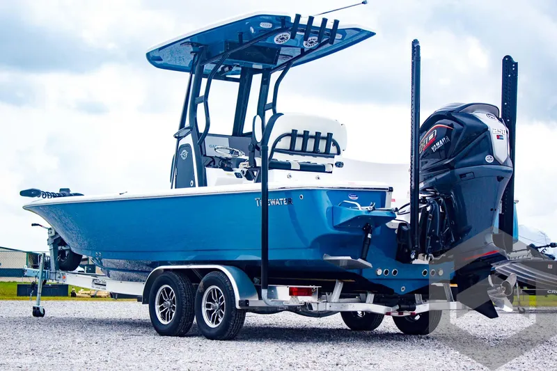 Slide: The Image of 2025 Tidewater 2410 Bay Max boat on trailer, featuring blue hull and powerful outboard motor. - 8