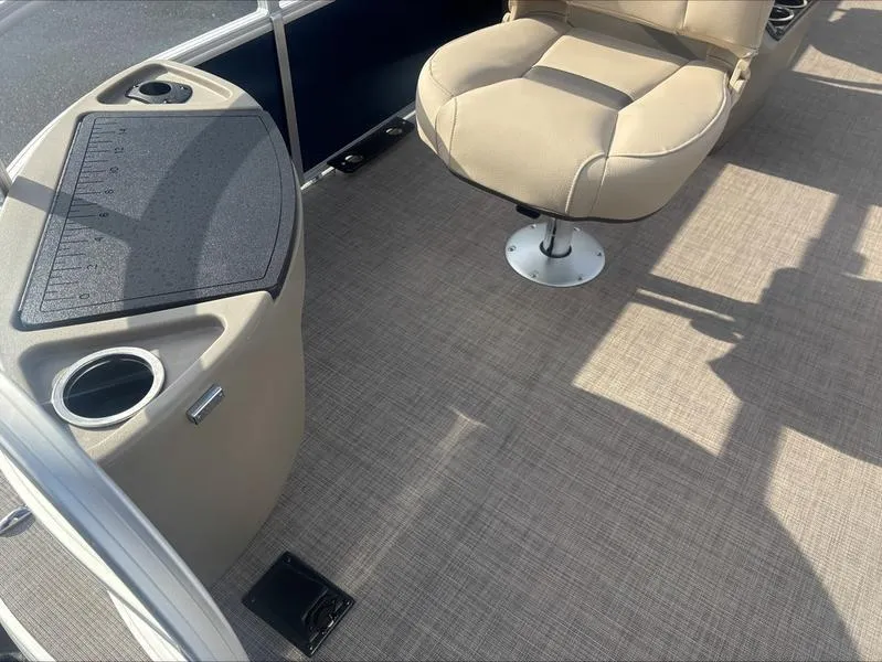 Slide: The Image of 2025 Sun Tracker BB 18 DLX boat interior with beige seating and cup holders. - 5