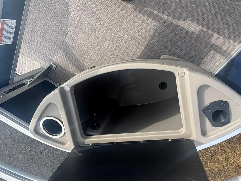 Slide: The Image of Storage compartment on a 2025 Sun Tracker BB 18 DLX boat, featuring cup holder and speaker. - 7