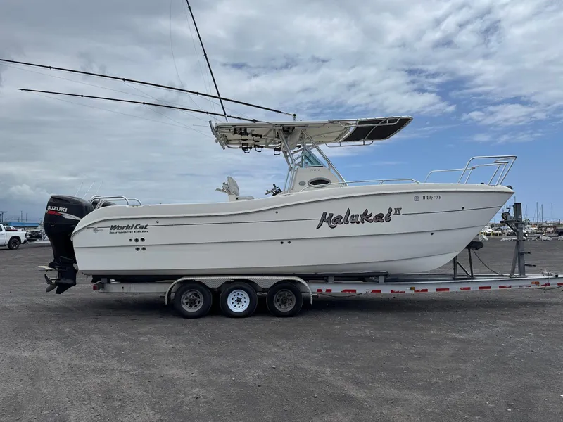 Slide: The Image of 2009 World Cat 270 TE boat on trailer, parked outdoors under cloudy sky. - 12