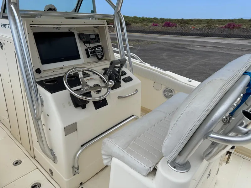 Slide: The Image of 2009 World Cat 270 TE boat helm with steering wheel and navigation controls. - 16