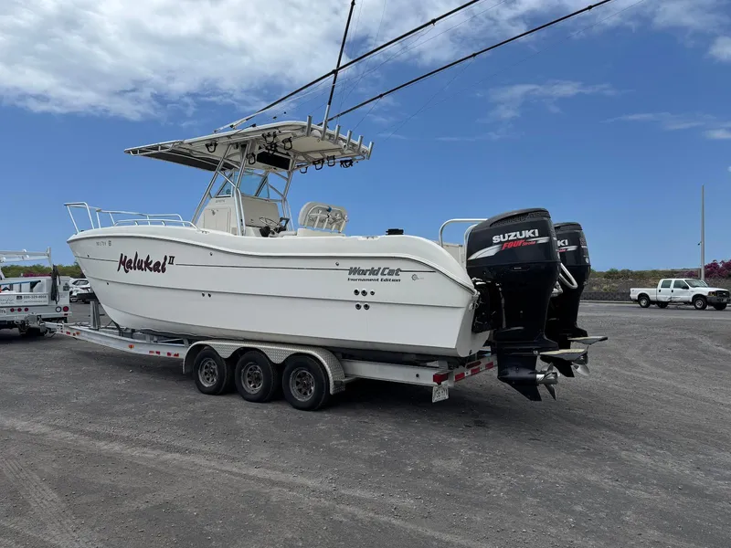 Slide: The Image of 2009 World Cat 270 TE boat on trailer with dual Suzuki engines, parked outdoors. - 9