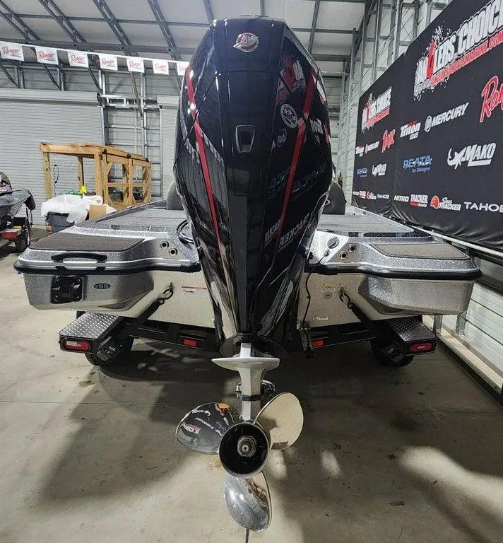 Slide: The Image of 2025 Triton 20XP Patriot boat in showroom, rear view with powerful outboard motor. - 3