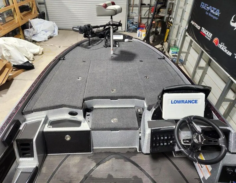 Slide: The Image of 2025 Triton 20XP Patriot boat interior with Lowrance electronics and steering wheel in a garage setting. - 7