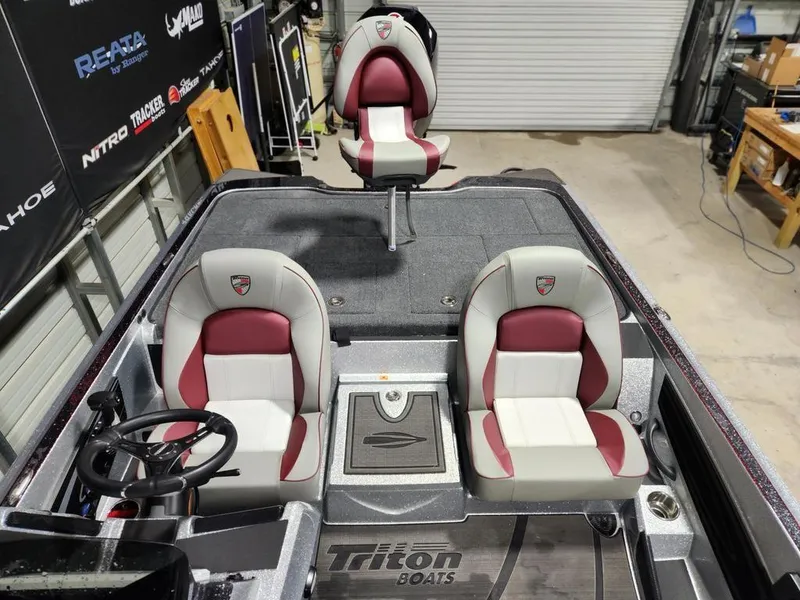 Slide: The Image of 2025 Triton 20XP Patriot boat interior with red and white seats in a garage setting. - 9