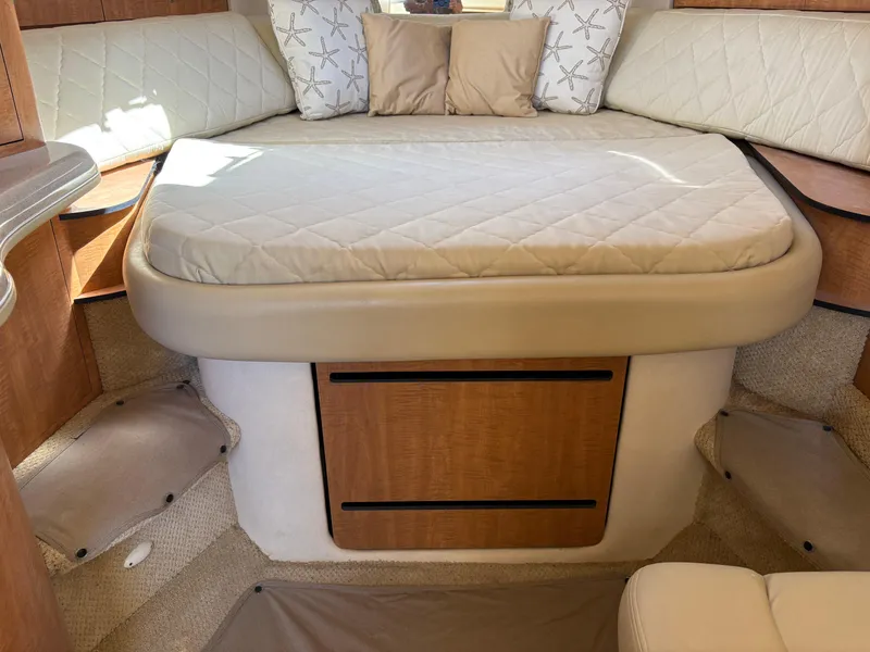 Slide: The Image of 2006 Sea Ray 320 Sundancer cabin interior with bed and starfish-patterned pillows. - 12