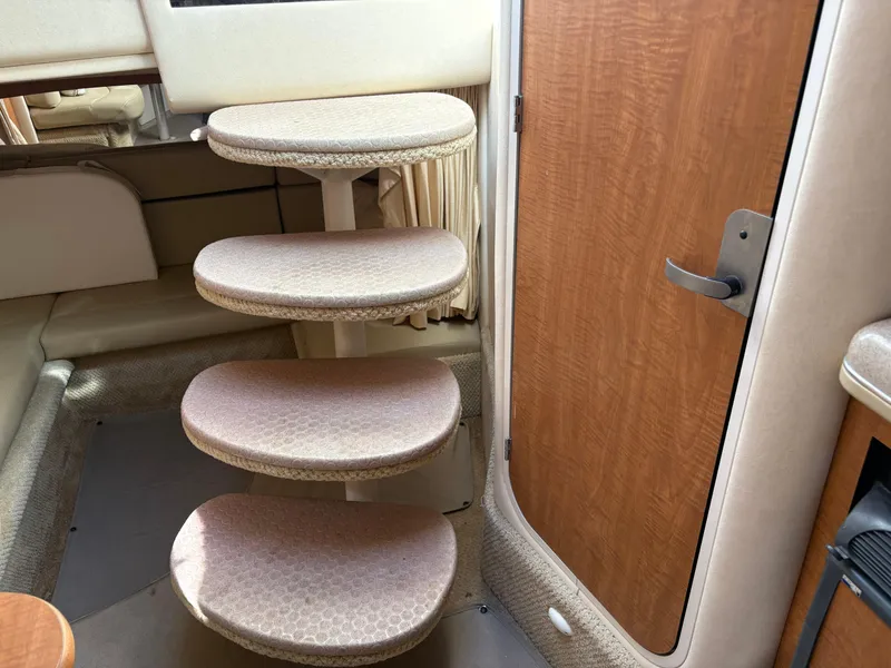 Slide: The Image of Interior stairs of 2006 Sea Ray 320 Sundancer yacht, featuring wooden door and carpeted steps. - 15