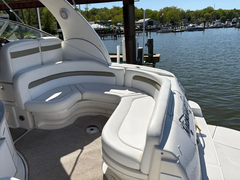 Slide: The Image of 2006 Sea Ray 320 Sundancer boat with white seating, docked by a marina. - 6