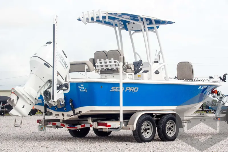 Slide: The Image of 2023 Sea Pro 208 Bay boat on trailer, blue and white design, outboard motor. - 11