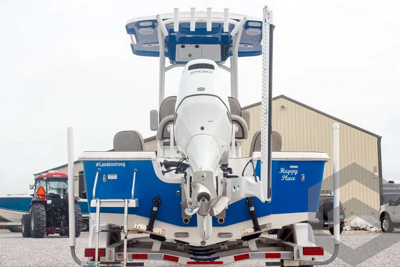 Slide: The Image of 2023 Sea Pro 208 Bay boat, rear view, blue and white design, parked outdoors. - 12