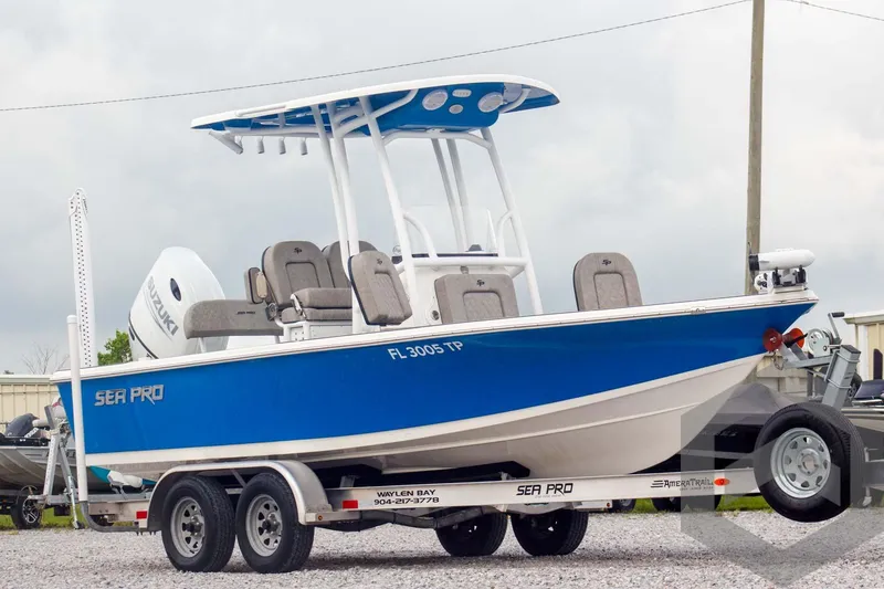 Slide: The Image of 2023 Sea Pro 208 Bay boat on trailer, blue and white design, parked outdoors. - 3