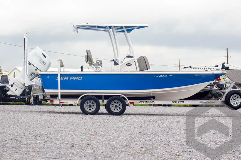 Slide: The Image of 2023 Sea Pro 208 Bay boat on trailer, blue and white design, parked outdoors. - 4
