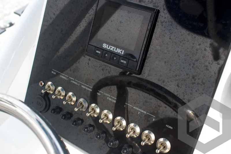 Slide: The Image of 2023 Sea Pro 208 Bay dashboard with Suzuki display and control switches. - 41