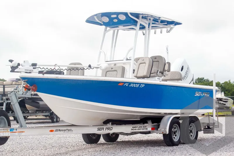 Slide: The Image of 2023 Sea Pro 208 Bay boat on trailer, blue and white design, parked outdoors. - 7