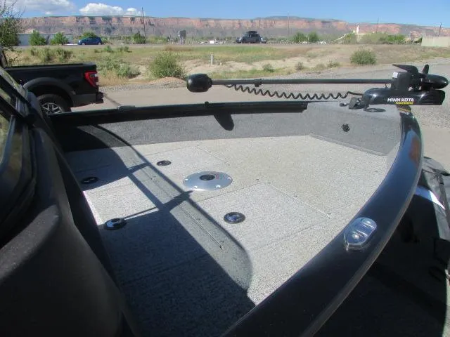 Slide: The Image of 2023 Tracker Pro Guide V16WT boat deck with Minn Kota trolling motor, parked outdoors. - 8