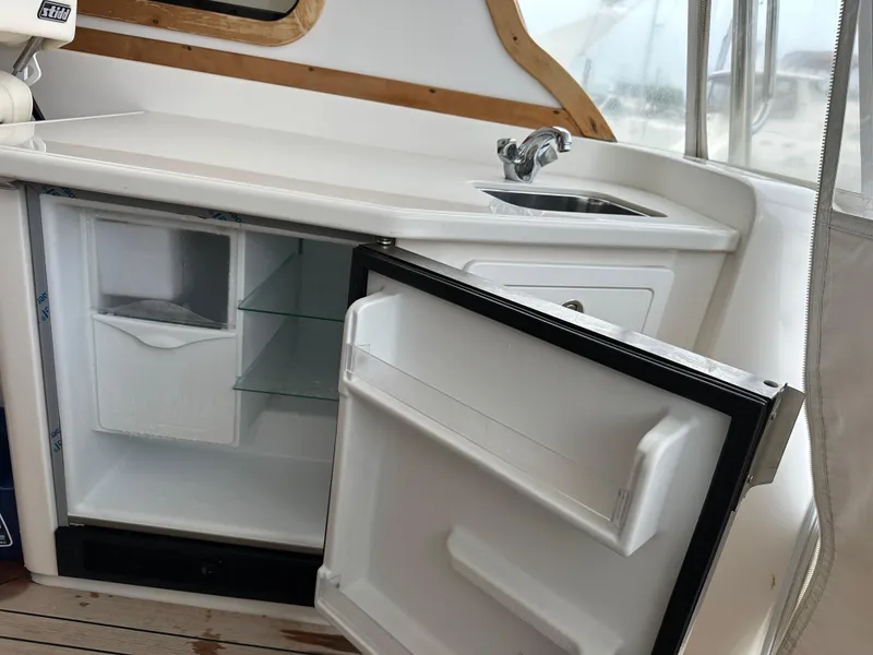 Slide: The Image of 2005 Sabre 38 Hardtop Express yacht interior with open mini fridge and sink. - 16