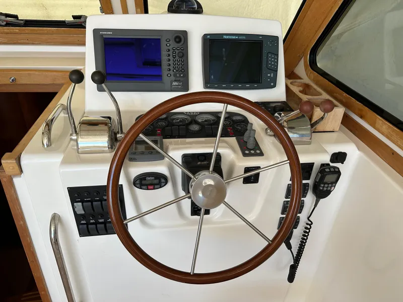 Slide: The Image of 2005 Sabre 38 Hardtop Express helm with steering wheel and navigation controls. - 17