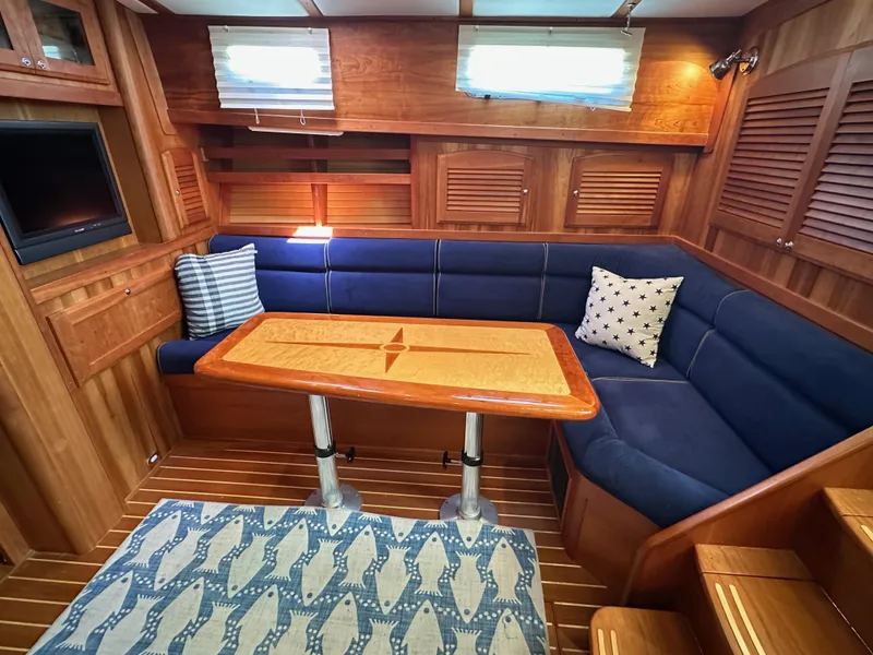 Slide: The Image of Interior of 2005 Sabre 38 Hardtop Express with blue seating and wooden table. - 21