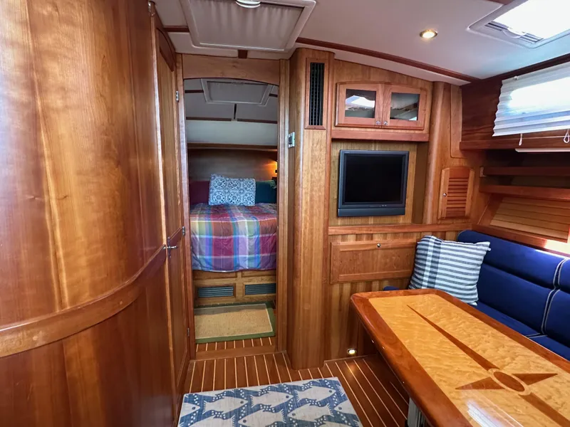 Slide: The Image of Interior of 2005 Sabre 38 Hardtop Express with wood finish, cozy seating, and a TV. - 25
