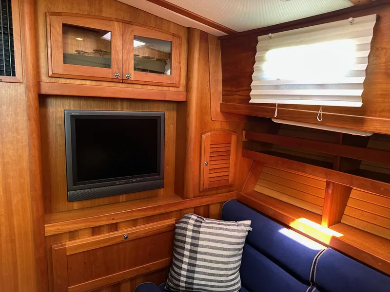 Slide: The Image of Interior of 2005 Sabre 38 Hardtop Express with wood paneling, TV, and blue seating. - 26