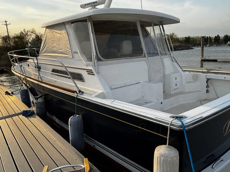 Slide: The Image of 2005 Sabre 38 Hardtop Express docked at marina, featuring sleek design and enclosed cabin. - 3