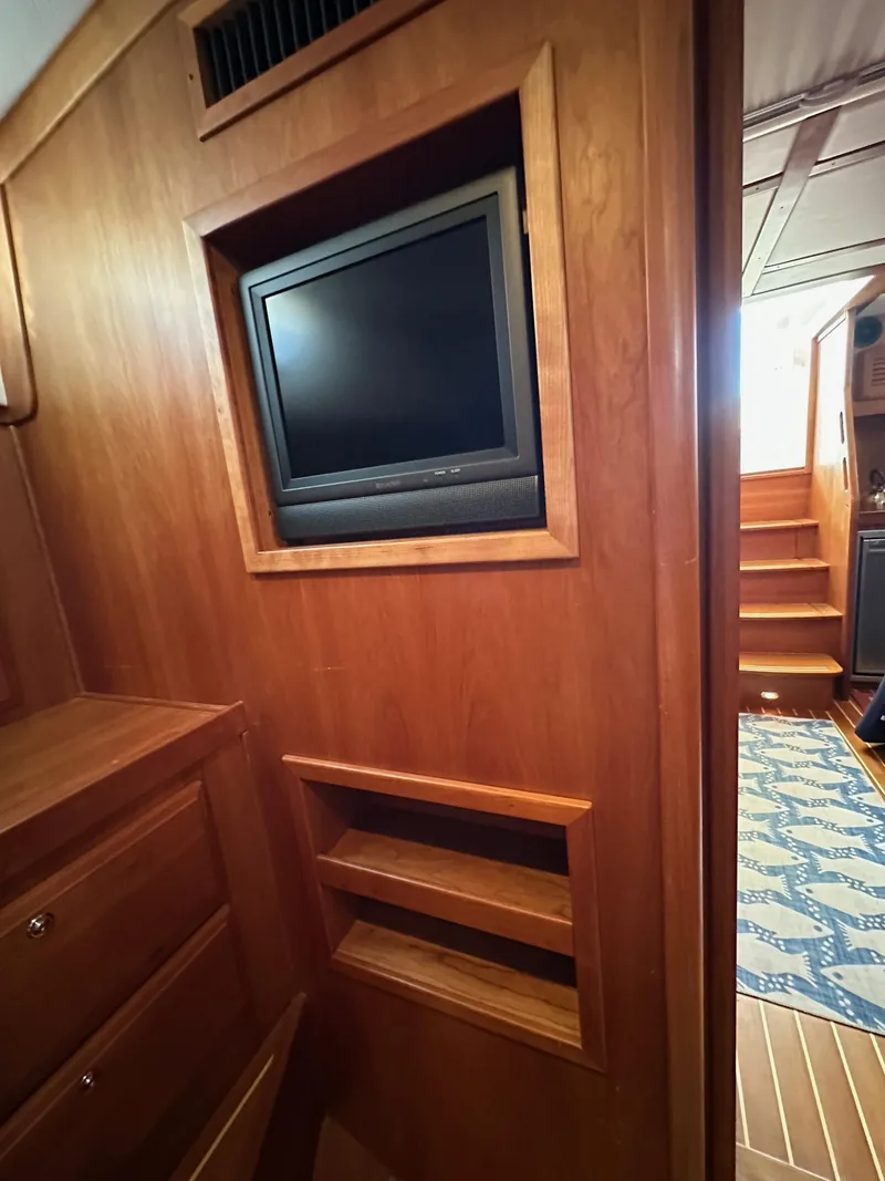 Slide: The Image of 2005 Sabre 38 Hardtop Express interior with built-in TV and wooden cabinetry. - 33