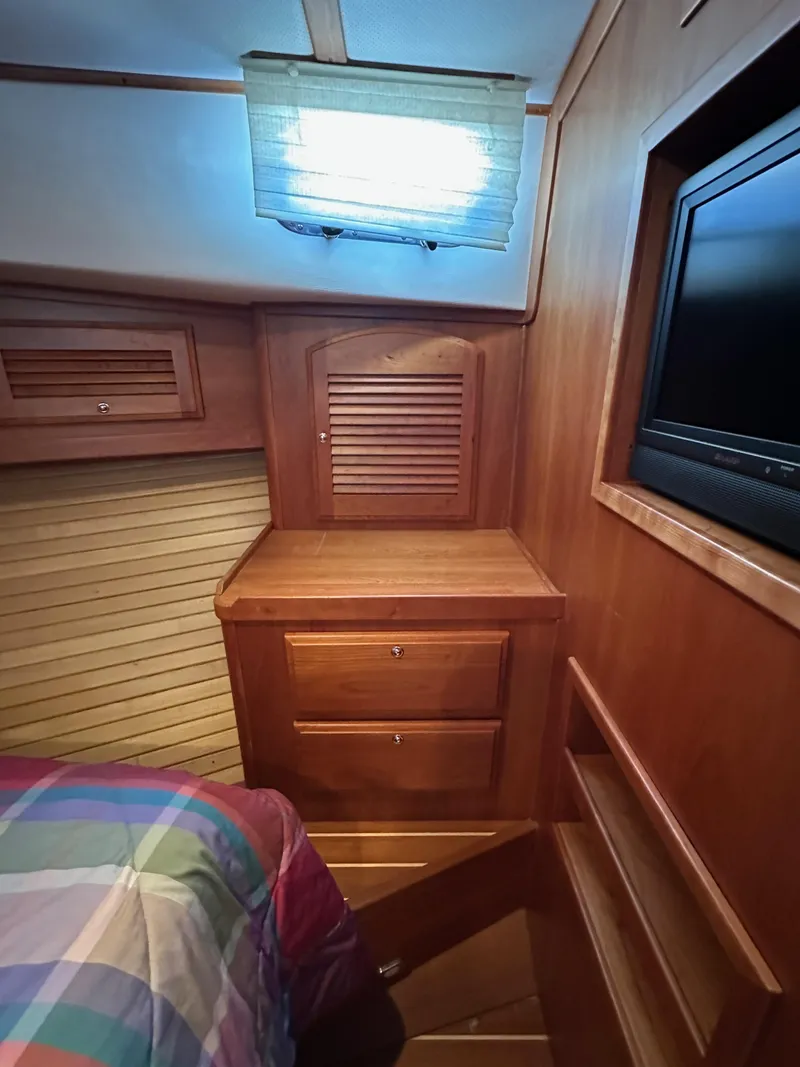 Slide: The Image of 2005 Sabre 38 Hardtop Express cabin interior with wood cabinetry and a TV. - 34