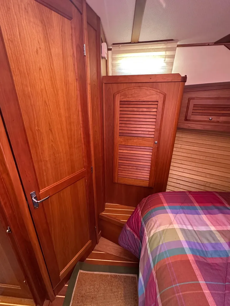 Slide: The Image of Interior of 2005 Sabre 38 Hardtop Express with wooden cabinetry and colorful bedding. - 35