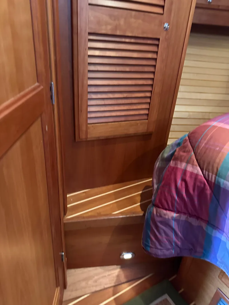Slide: The Image of Interior of 2005 Sabre 38 Hardtop Express with wooden cabinetry and colorful bedding. - 37