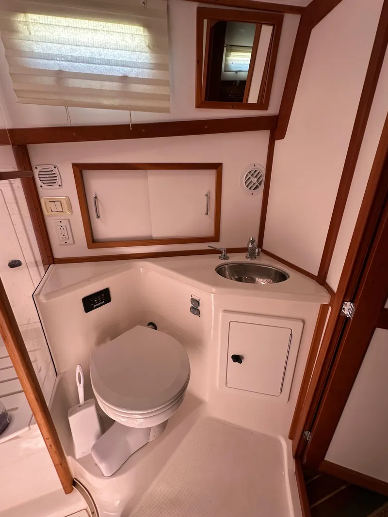 Slide: The Image of 2005 Sabre 38 Hardtop Express bathroom with sink, toilet, and storage cabinets. - 38