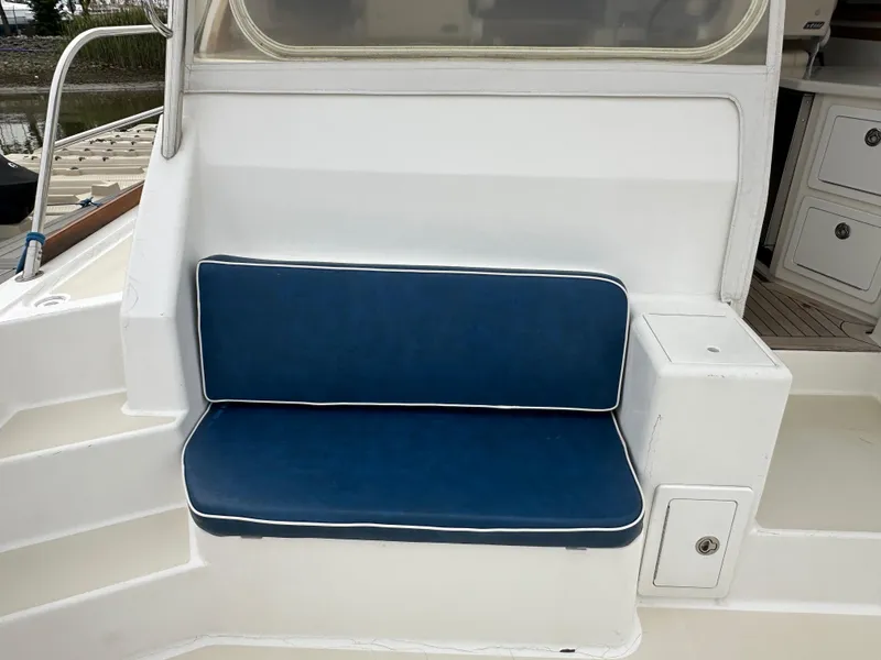 Slide: The Image of 2005 Sabre 38 Hardtop Express boat seat with blue cushion and white trim. - 52