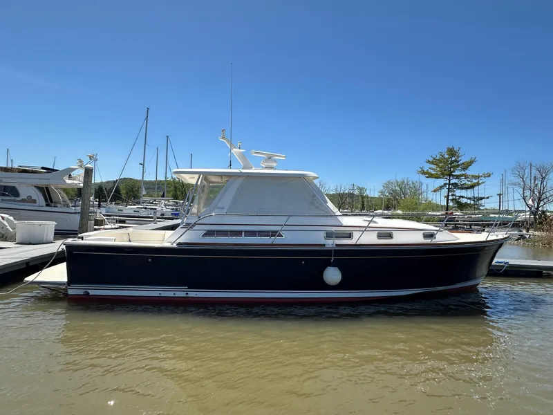 Slide: The Image of 2005 Sabre 38 Hardtop Express boat docked in marina under clear blue sky. - 7