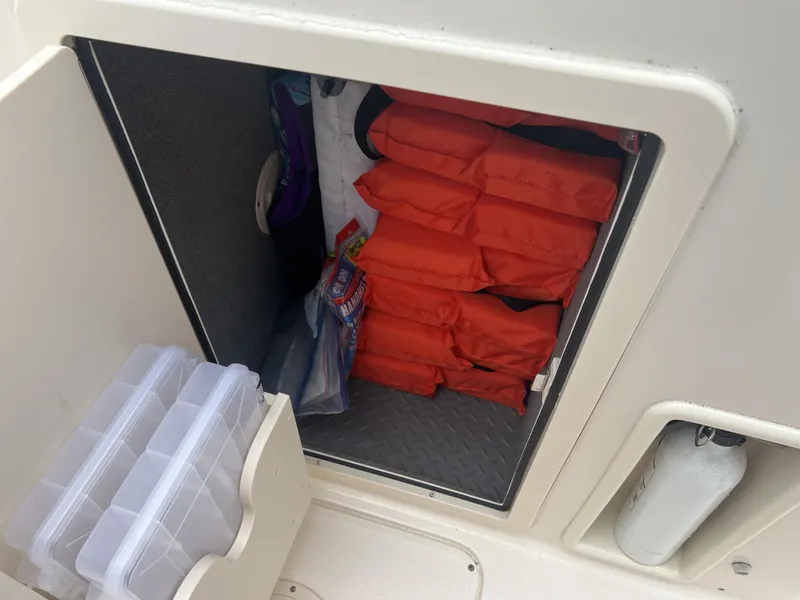 Slide: The Image of Storage compartment on a 2021 Grady-White Freedom 215 boat with life jackets and gear. - 12