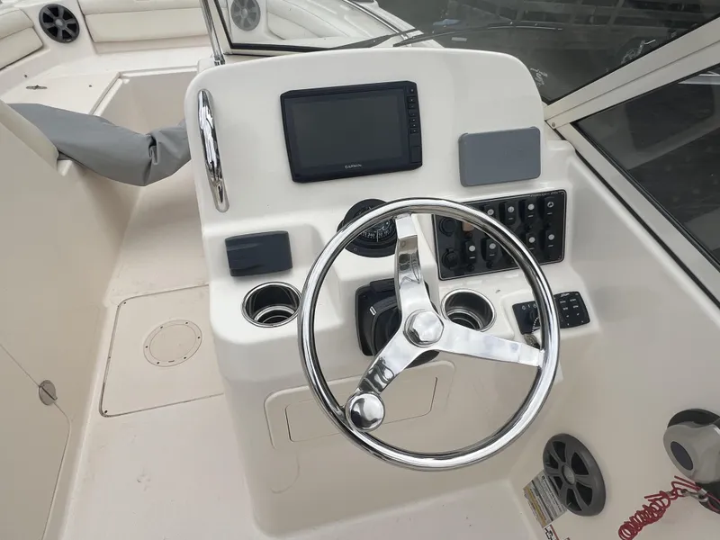 Slide: The Image of 2021 Grady-White Freedom 215 boat dashboard with steering wheel and controls. - 14