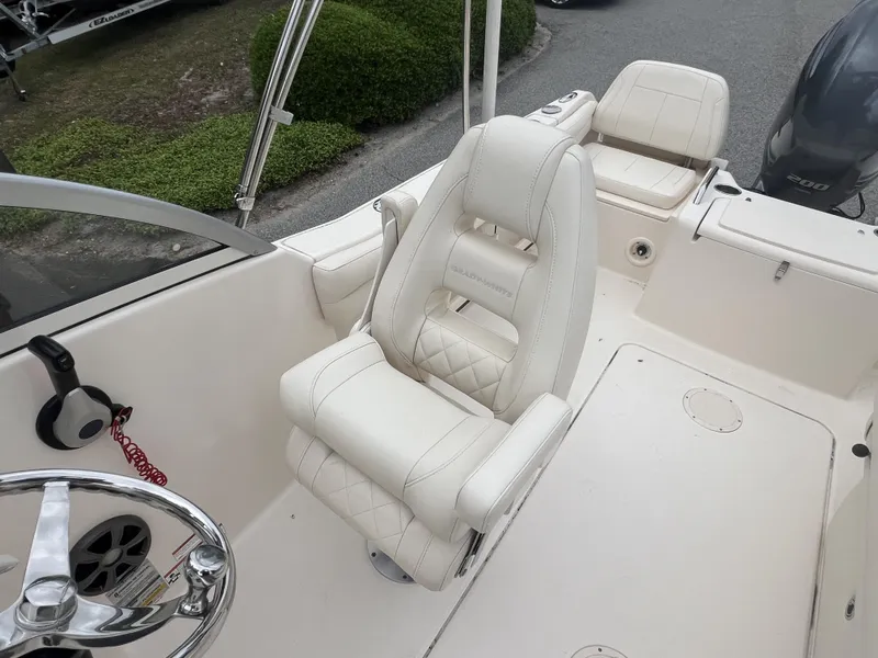 Slide: The Image of 2021 Grady-White Freedom 215 boat interior with white seating and steering wheel. - 4