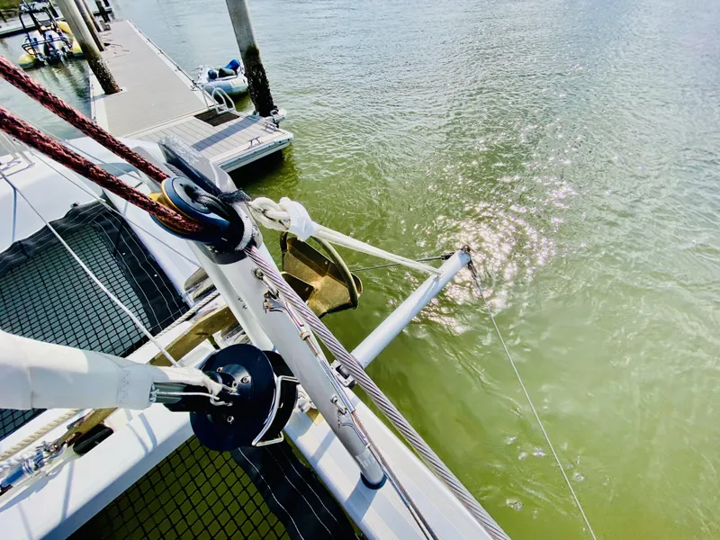 Slide: The Image of 2019 Lagoon 42 Owners Version catamaran docked, showing deck and water reflections. - 12