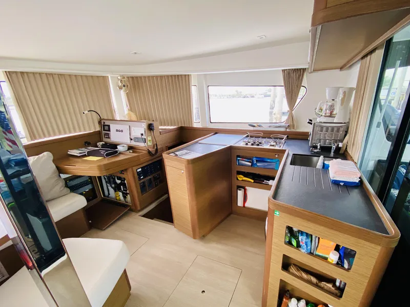 Slide: The Image of Interior of 2019 Lagoon 42 Owners Version catamaran with modern kitchen and navigation area. - 19