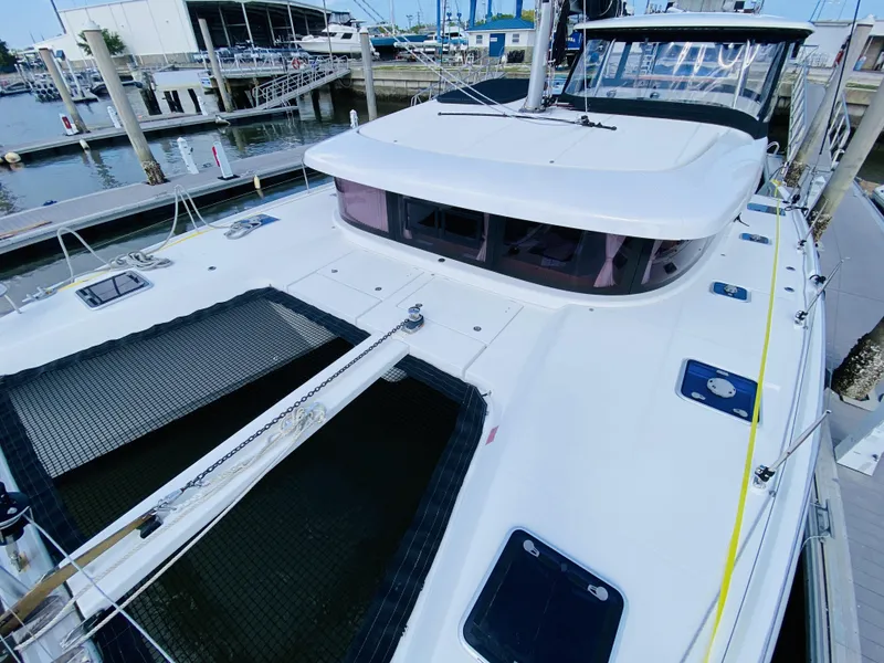 Slide: The Image of 2019 Lagoon 42 Owners Version catamaran docked at a marina. - 9