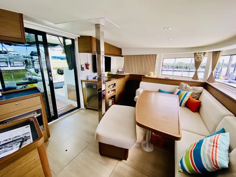 Slide: The Image of Interior of 2019 Lagoon 42 Owners Version catamaran with modern seating and vibrant cushions. - 2