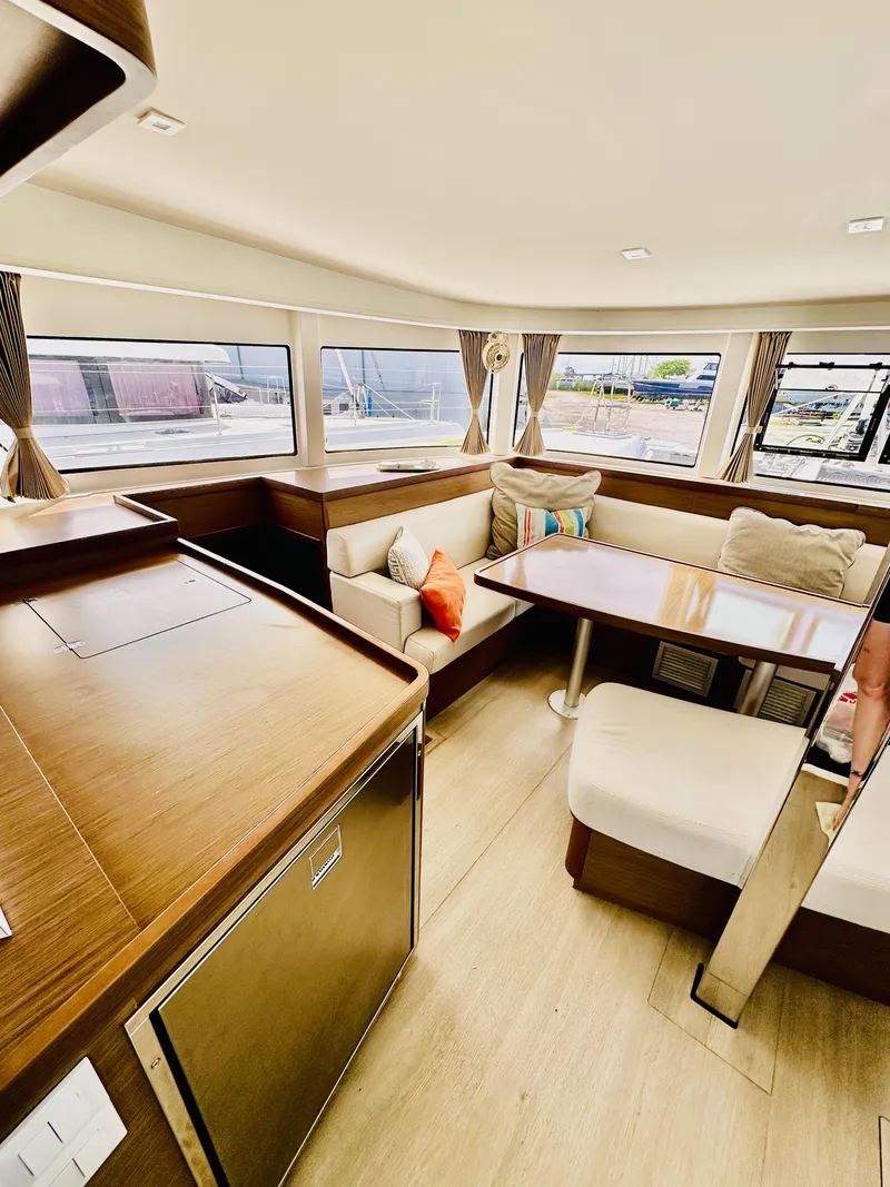 Slide: The Image of 2019 Lagoon 42 Owners Version interior with modern seating and large windows. - 23