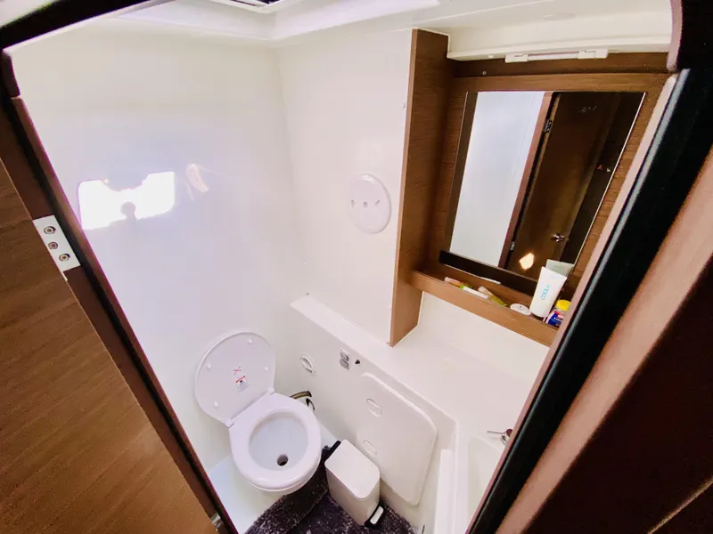 Slide: The Image of Bathroom interior of 2019 Lagoon 42 Owners Version yacht, featuring toilet and mirror. - 39