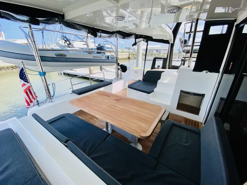 Slide: The Image of 2019 Lagoon 42 Owners Version yacht with spacious outdoor seating and dining area. - 6