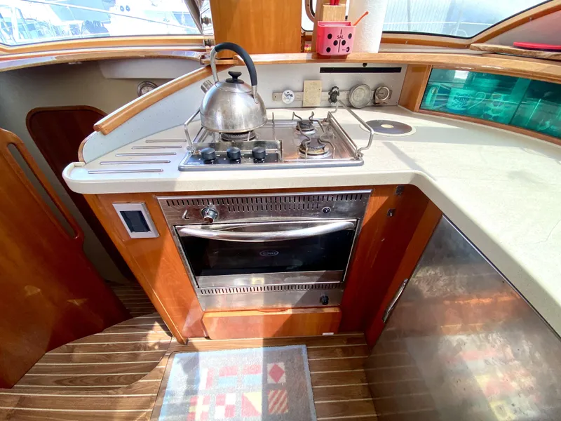 Slide: The Image of Galley kitchen in 2006 Privilege 435 yacht with stove, oven, and wooden cabinetry. - 24