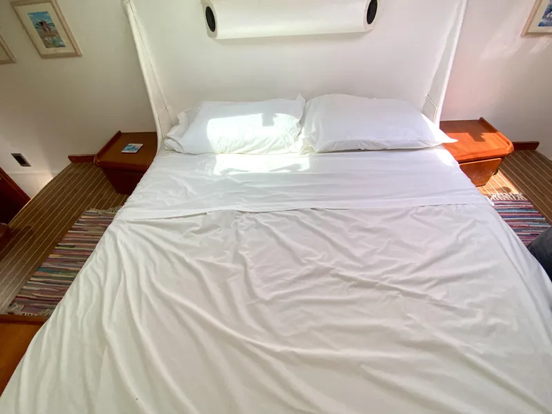 Slide: The Image of Bed in Privilege 435 yacht cabin, 2006 model, with white linens and wooden side tables. - 30