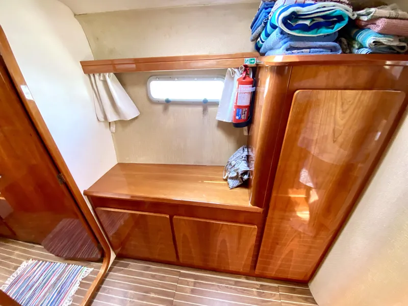 Slide: The Image of 2006 Privilege 435 yacht interior with wooden cabinetry, window, and neatly stacked towels. - 35