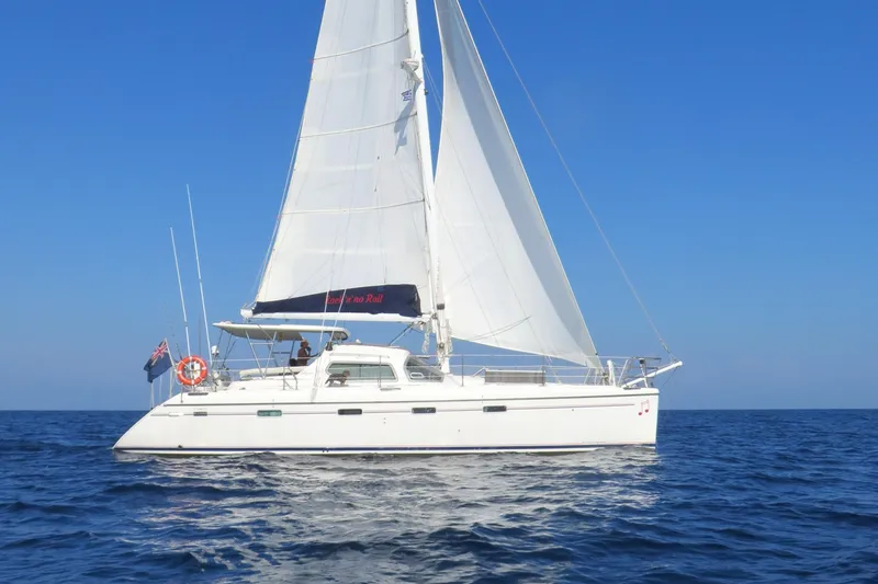 Slide: The Image of Privilege 435 catamaran sailing on open sea, 2006 model, under clear blue sky. - 4