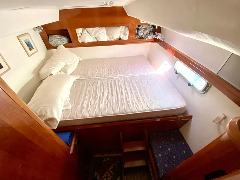 Slide: The Image of 2006 Privilege 435 yacht cabin with double bed, wooden interior, and porthole window. - 44